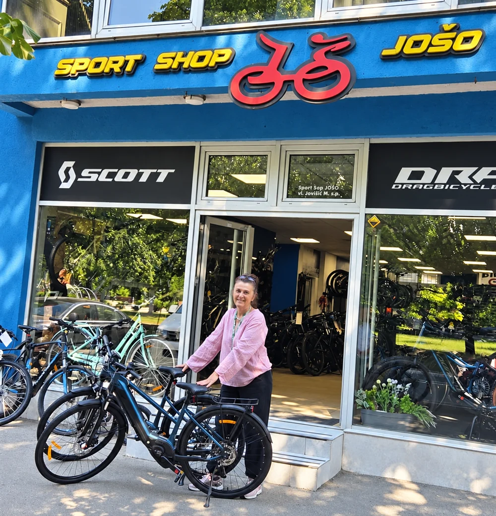 Anela Dedić with electric bicycles outside the bicycle shop