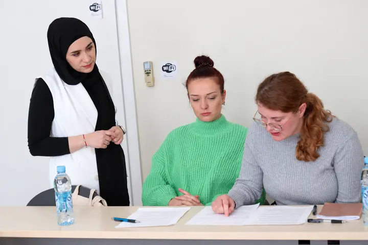 Three women reviewing documents together at a table