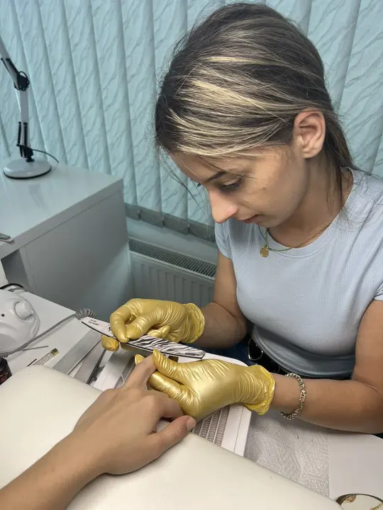 A woman working carefully on a nail treatment