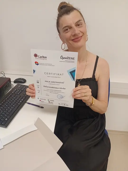 A woman holding a training certificate