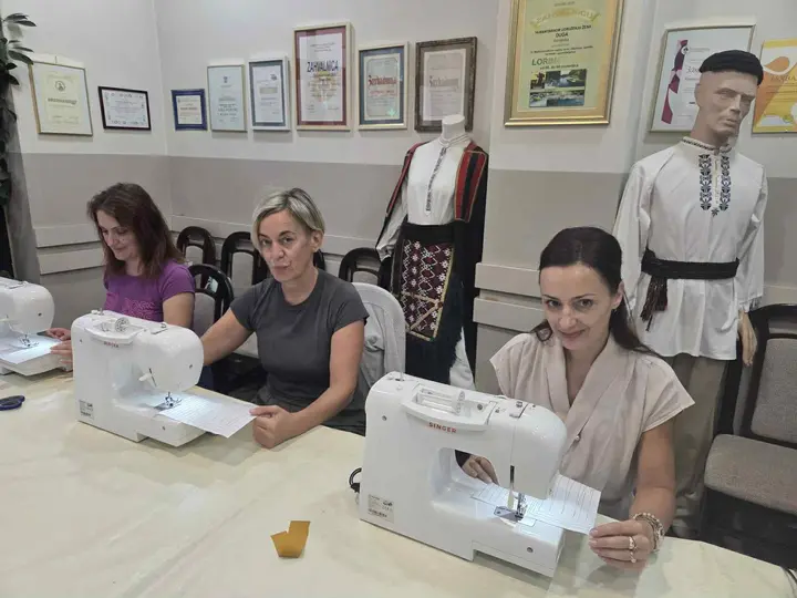 Women practising with sewing machines in a training room