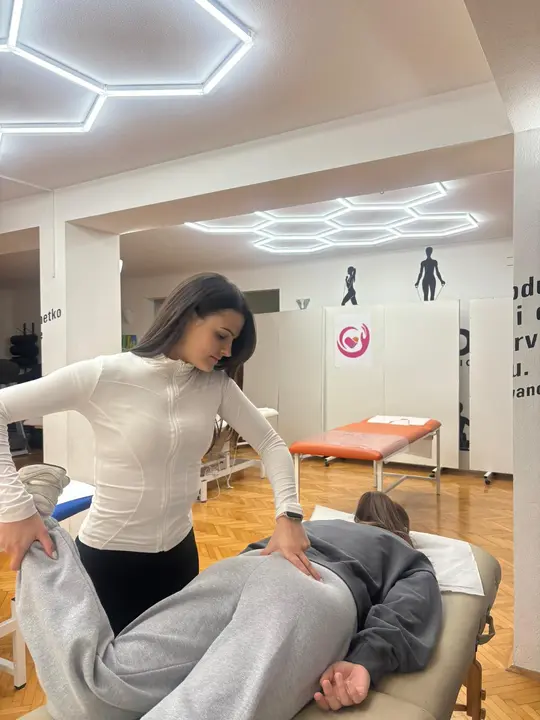 A woman practising a hands-on technique in a treatment studio